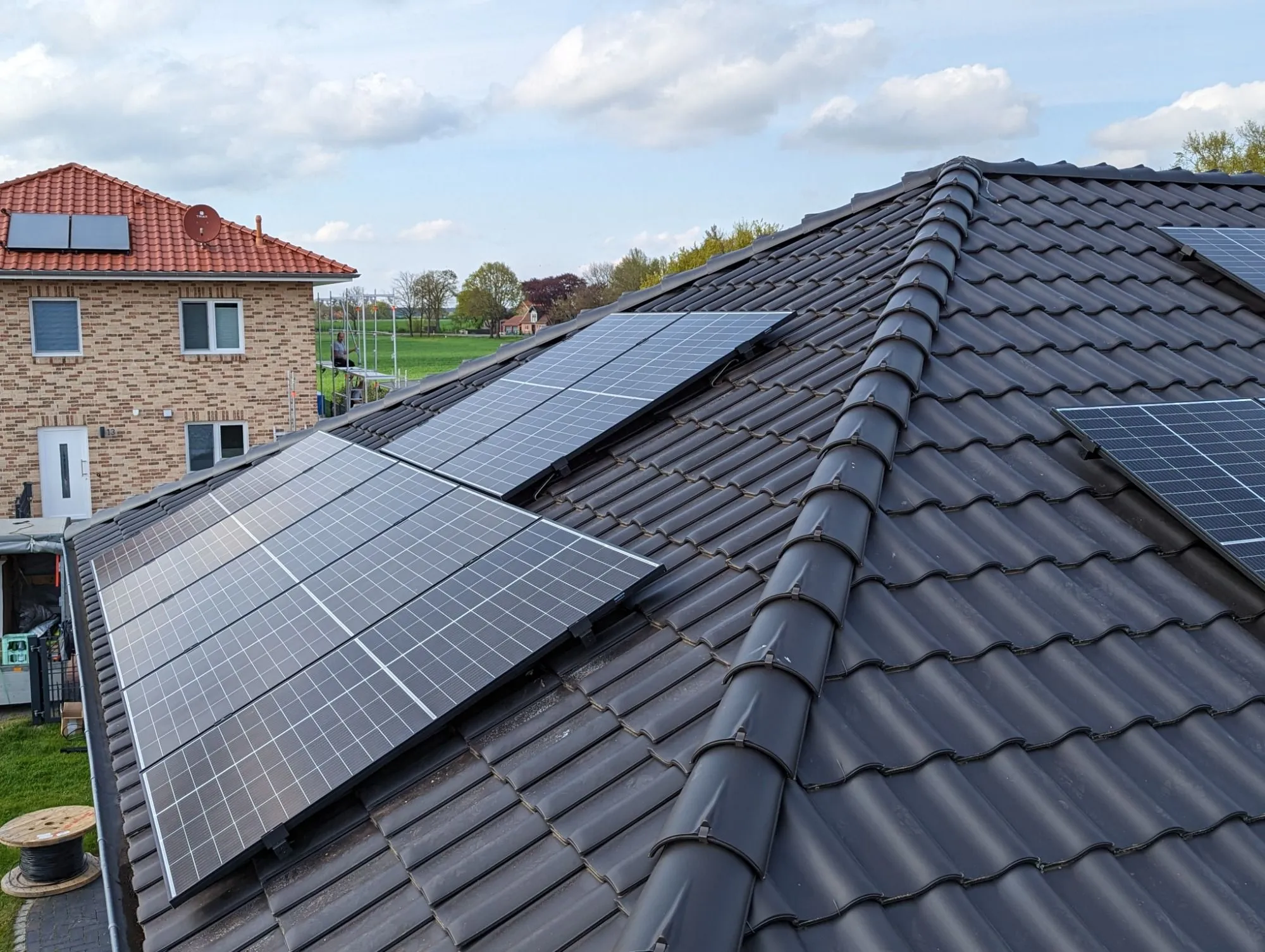 Ziegeldach eines Wohnhauses, vollflächig mit schwarzen Photovoltaikmodulen belegt